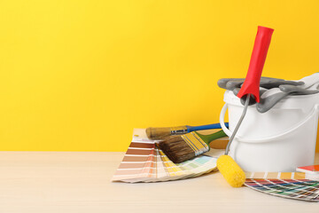 Different painter's tools on white wooden table, space for text. Decorating and design
