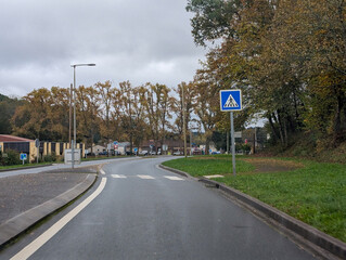 Roadway with crosswalk sign in autumn Dordogne France countryside