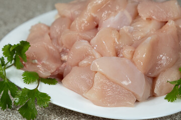 Close-up of pieces of uncooked fresh raw chicken fillet in a plate.