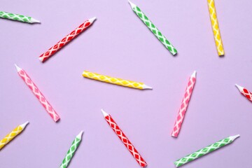 Multi-colored holiday candles on color background, flat lay. Birthday concept 