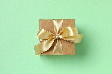 Beautiful gift box tied with bow on color background 