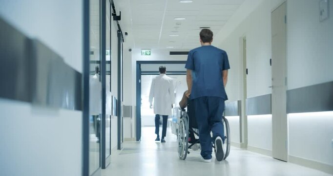 Hospital Hallway with Doctors, Nurses and Specialists in Hospital. Female and Male Physicians, Surgeons, Healthcare Officials Walk Together in Corridor with Their Back to Camera. Slow Motion Footage