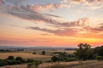 Fototapeta premium Warm golden hues of sunset fade into a vast expanse of cloudless summer sky with hues of pink and orange softening towards the horizon, warm colors, peaceful atmosphere,