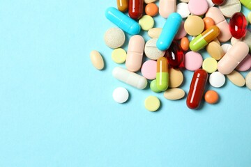 Various pills and capsules on a color background