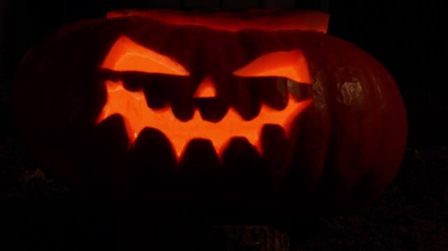 vid&eacute;o avec une t&ecirc;te de citrouille halloween allum&eacute;e par des bougie, vid&eacute;o avec zoom arri&egrave;re lent,  apparition d'une citrouille halloween, pour f&ecirc;tes