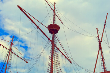 Clear blue sky, double mast sail boat, sails down, slight breeze