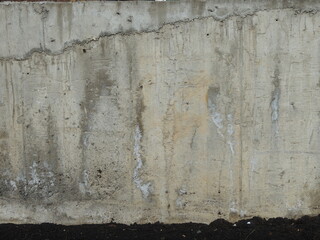 fragment of concrete wall with cracks and stains, grunge texture of urban space, graphic background of cement surface in the process of deterioration