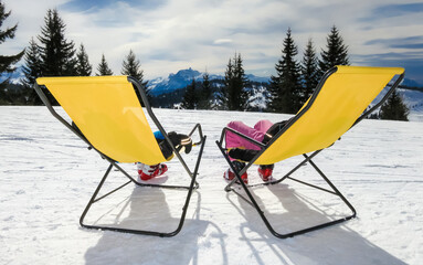Two children on the lounge chairs on mountain