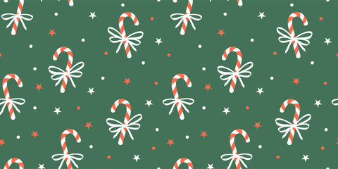 Seamless Christmas pattern with candy canes, bows and stars on green background. Winter vector decor. Sample for wrapping paper, fabric, cover.