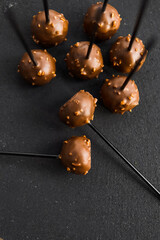 Round chocolate candies on a black background. Group of chocolate candies. Concept of chocolate products