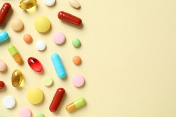 Various medicine pills and capsules on color background 