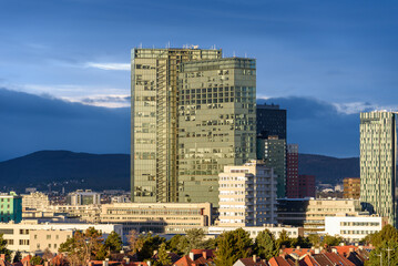 Vienna Twin tower on Wienerberg with 3 empty floors in the morning sun against a dark sky in the background