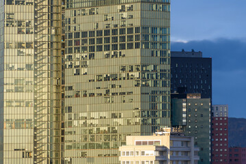 Close up of the Vienna Twin tower on Wienerberg with 3 empty floors in the morning sun against a dark sky in the background