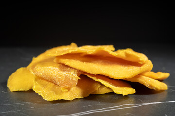 Sliced Dried Mango, Dried Fruit. Candied fruits, mango pieces. Heap of candied slices, crystallized fruit