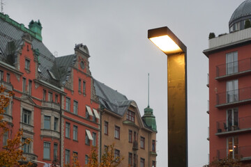 A modern street lamp with buildings in the background