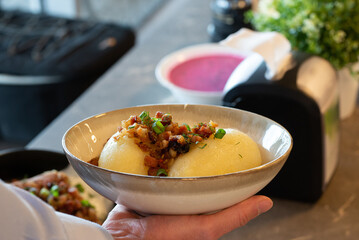 Traditional Lithuanian dish of stuffed potato dumplings (cepelinai). The dumplings are made from grated and riced potatoes and stuffed with ground meat or dry curd cheese or mushrooms
