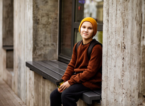 Urban autumn vibe with person in cozy attire drinking coffee