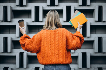 Female student stands against an abstract geometric wall design