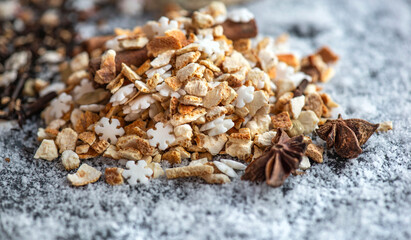 winter hot drink ingredient pile with spices, star-shaped and sugar  on table on snowy background