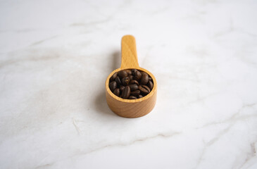 Coffee beans in a wooden spoon on White Background