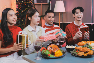 Friends opening Christmas gifts in living room