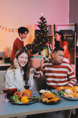 Friends opening Christmas gifts in living room