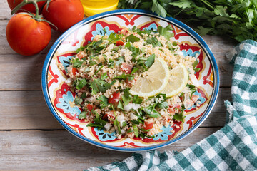 Tabbouleh salad with couscous on wooden table