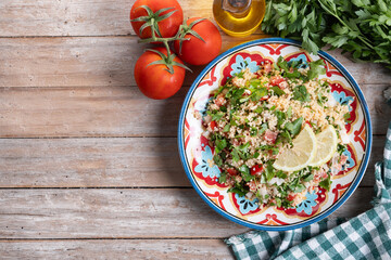 Tabbouleh salad with couscous on wooden table. Top view. Copy space