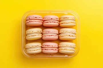 Fototapete Rund A clear container holding colorful macarons on a bright yellow background. © The Stock Photo Girl