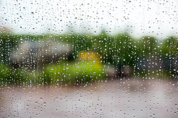 Raindrops on the glass. It's raining outside the window.