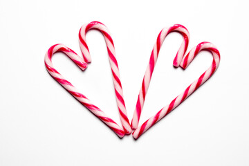 Heart-shaped arrangement of candy canes on a white background for festive celebrations