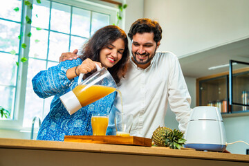 Indian asian couple bonding over fresh pineapple juice preparation, health and nutrition at home