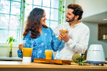 Indian asian couple bonding over fresh pineapple juice preparation, health and nutrition at home