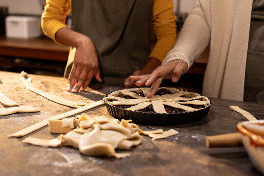 Grandma and asian female teenager baking pie together, at home