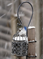 Snow falling on garden lamp light