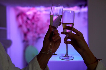 Romantic toast with champagne glasses in a softly lit spa.