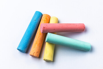 Crayons of different colors arranged on a white background. Education