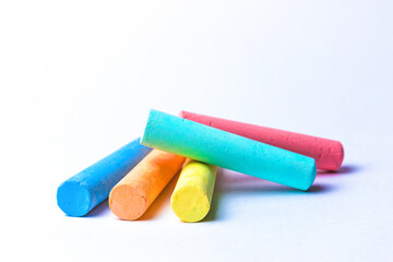 Crayons of different colors arranged on a white background. Education