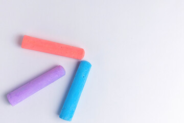 Crayons of different colors arranged on a white background. Education