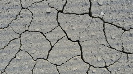 Fototapeta premium A close-up of rough, stony textured surface with natural cracks and crevices, stone wall