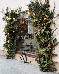 The store front is beautifully decorated for the Christmas season, showcasing a vibrant and eyecatching tree in the window for all to admire and fully enjoy the festive holiday atmosphere