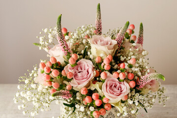 Wedding bouquet with pink roses, hypericum, veronica smart and gypsophila paniculata twigs.