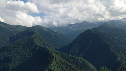 
This breathtaking photo captures the lush, green expanses of the Caucasus Mountains. The rolling hills are blanketed in vibrant greenery, highlighting the rugged, untouched beauty of the region