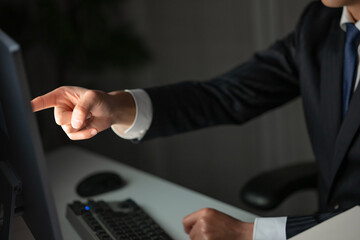 パソコンの画面に指差しをする男性