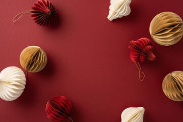 A collection of decorative paper ornaments in red, white, and gold displayed on a rich red backdrop, offering a festive and elegant holiday theme