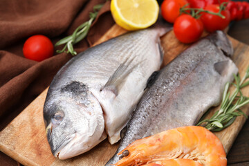 Fresh raw sea food and products on wooden table, closeup