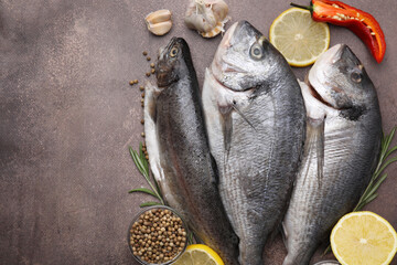 Sea food. Different types of raw fish and products on brown table, flat lay. Space for text