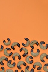 home made nougat crescents cookies with chocolate at the edge on orange background with copy space above