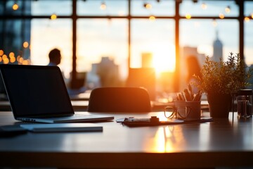 A modern office desk displays a laptop and other items against a sunset cityscape, highlighting the blend of work and leisure with a warm, inviting atmosphere.