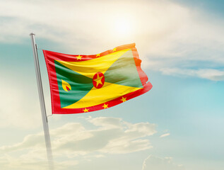 Grenada national flag waving in beautiful sky with mast. A proud moment flag waving with sunlight.